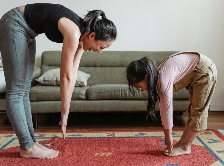 Mother and child stretching together at home, representing daily routine and everyday life